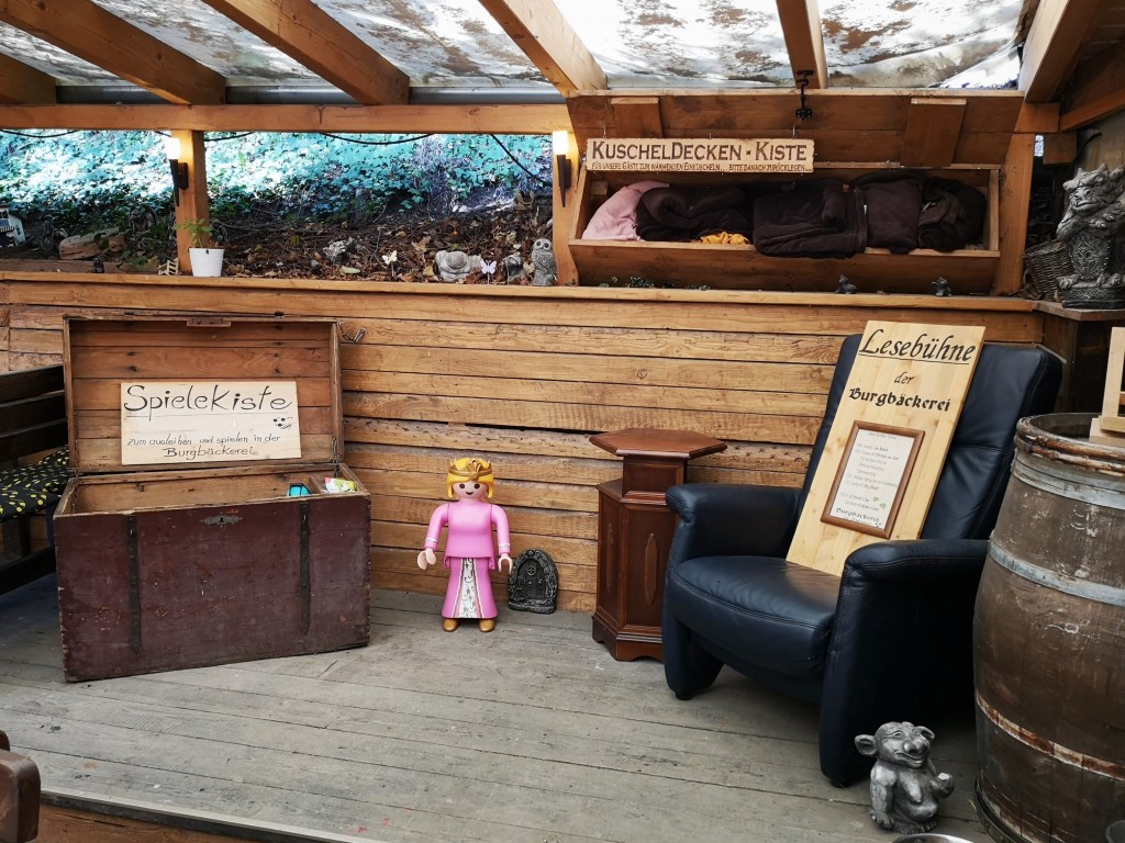 Blick auf die Lesebühne mit Spielkiste und Kuscheldecken-Kiste